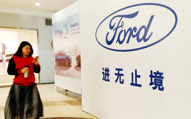 A pedestrian walks past a billboard for Ford in Ji'nan City in Shandong Province on March 31, 2019. [Photo: IC]