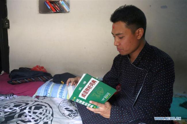 Binaya Hada reads a Chines dictionary(字典 zìdiǎn) at his home in Bhaktapur, Nepal on May 15, 2019.[Photo: Xinhua/Sunil Sharma]