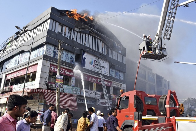 Firefighters work to douse flames on a building in Surat, in the western Indian state of Gujarat, Friday, May 24, 2019. [Photo: IC]