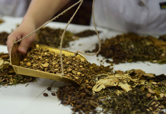 A doctor prepares traditional Chinese medicines for the patients at People's Hospital of Cangzhou, Hebei Province, May 26, 2019. [Photo: IC]<br/>