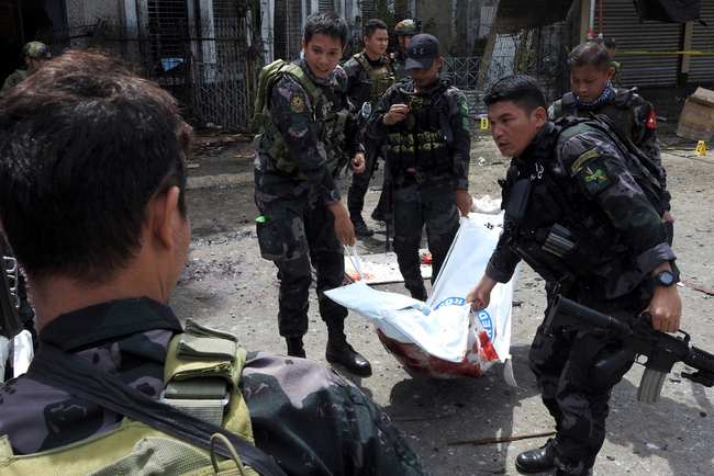 Philippine security personnel carry a body bag containing the remains of a blast victim after two bombs exploded at a church in Jolo, Sulu Province on the southern island of Mindanao, on January 27, 2019. [File Photo: AFP]