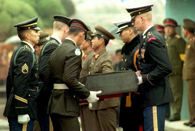 North Korean soldiers hand over remains of U.S servicemen killed during the Korean War to United Nations honor guards at the Military Demarcation Line dividing Panmunjom 30 November 1993. U.S. Colonel Forrest Chilton accepted remains and said that discussions were underway for future transfers. [Photo: AFP]