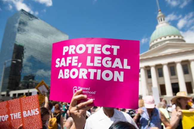 Protesters hold signs as they rally in support of Planned Parenthood and pro-choice and to protest a state decision that would effectively halt abortions by revoking the center's license to perform the procedure, near the Old Courthouse in St. Louis, Missouri, May 30, 2019. [Photo: AFP]