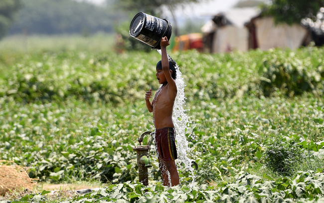 In this file photo taken on May 29, 2019, an Indian boy pours water on himself as he tries to cool himself off amid rising temperatures in New Delhi. [Photo: AFP]