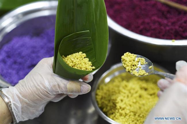 A worker makes colorful Zongzi, pyramid-shaped dumplings made of glutinous rice wrapped in bamboo or reed leaves, at a factory in Taijiang County, southwest China's Guizhou Province, June 2, 2019.[Photo: Xinhua/Liu Kaifu]