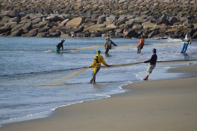 Fishermen pull in their fishing nets along the shore in Banda Aceh, Indonesia on May 24, 2019. [Photo: AFP]