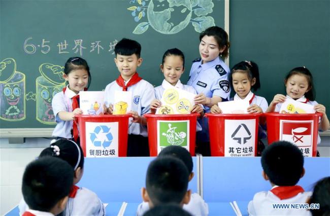Pupils learn the knowledge of garbage sorting at an elementary school in Xingtai, north China's Hebei Province, June 4, 2019. [Photo: Xinhua]
