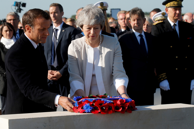 French President Emmanuel Macron and British Prime Minister Theresa May lay a wreath of flowers during a ceremony to lay the first stone of the British Normandy Memorial in Ver-sur-Mer, Normandy, northwestern France, on June 6, 2019, as part of D-Day commemorations marking the 75th anniversary of the World War II Allied landings in Normandy. [Photo: Pool/AFP/Philippe Wojazer]