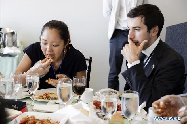 People eat crayfish during the Qianjiang crayfish tasting party at the United Nations headquarters in New York, June 4, 2019. [Photo: Xinhua]