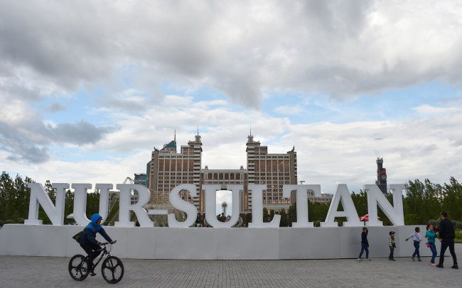 A man rides a bicycle past large letters reading "Nur-Sultan" in downtown Nur-Sultan on June 7, 2019, ahead of Kazakhstan's presidential elections on June 9. [Photo: AFP/ Vyacheslav OSELEDKO] 