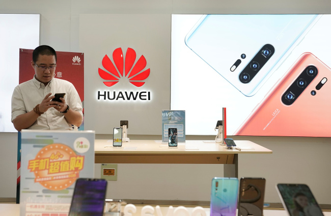 A customer waits to buy a new Huawei P30 smartphone before Huawei's P30 and P30 Pro go on sale at a Huawei store in Beijing, China, April 11, 2019. [Photo: VCG]