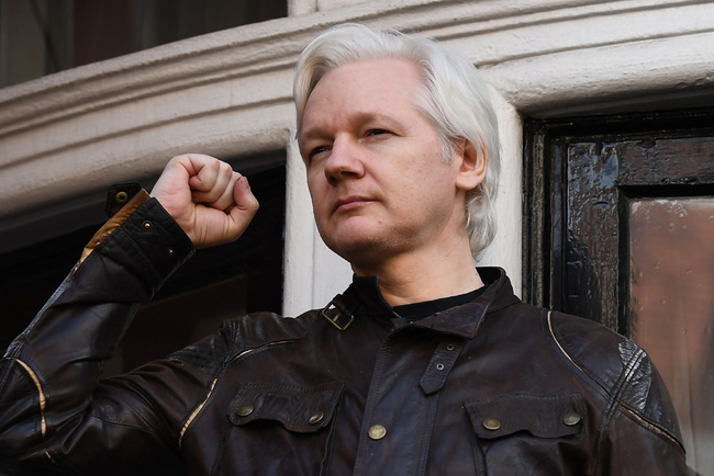 In this file photo taken on May 19, 2017 Wikileaks founder Julian Assange raises his fist prior to address the media on the balcony of the Embassy of Ecuador in London. [File Photo: AFP/Justin Tallis]