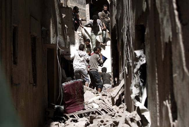 Yemenis sift the rubble of a heavily damaged building following reported Saudi-led coalition air strikes in the Yemeni capital Sanaa on May 16, 2019. [File photo: AFP]