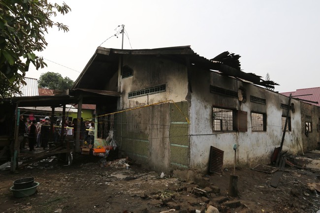 Locals stand outside a gas lighter factory site ravaged by a fire in Binjai, North Sumatra, Indonesia on June 21, 2019. [Photo: IC]