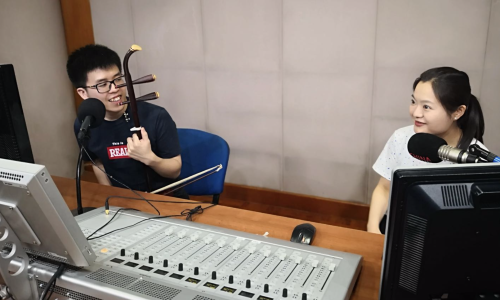 Zeng Jianhao(left), a Malaysian Chinese who learns erhu in Beijing, shares with us his love and dream for Erhu. [Photo by China Plus]