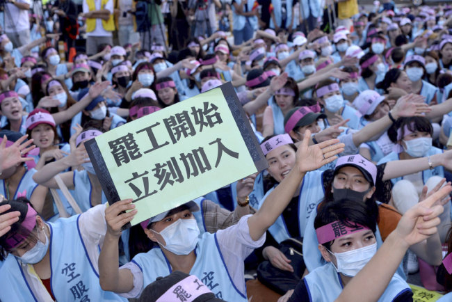 An EVA Air flight attendant holds up a sign which reads: "Strike begins, join immediately" during a protest at the EVA Air headquarters in Taoyuan, Taiwan, Friday, June 21, 2019. The strike by flight attendants at EVA Air, Taiwan's second-largest airline, has left thousands of passengers scrambling for alternative transport. [Photo: AP]