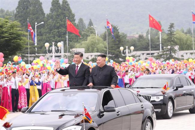 General Secretary of the Central Committee of the Communist Party of China (CPC) and Chinese President Xi Jinping and Kim Jong Un, chairman of the Workers' Party of Korea (WPK) and chairman of the State Affairs Commission of the Democratic People's Republic of Korea (DPRK), ride an open-top vehicle to the square of the Kumsusan Palace of the Sun amid welcoming crowds, following a grand welcoming ceremony held by the DPRK side at the Sunan International Airport, in Pyongyang, DPRK, June 20, 2019. [Photo: Xinhua/Ju Peng]