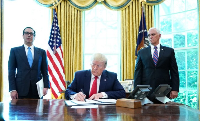US President Donald Trump signs with US Vice President Mike Pence(R) and US Secretary of Treasury Steven Mnuchin at the White House on June 24, 2019, 'hard-hitting sanctions' on Iran's supreme leader. [Photo: AFP]