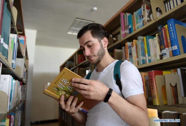 Aushev Djamaleil reads a book at the school library(图书馆 túshū guǎn) in Shaanxi University of Chinese Medicine in northwest China's Shaanxi Province. [Photo: Xinhua] 