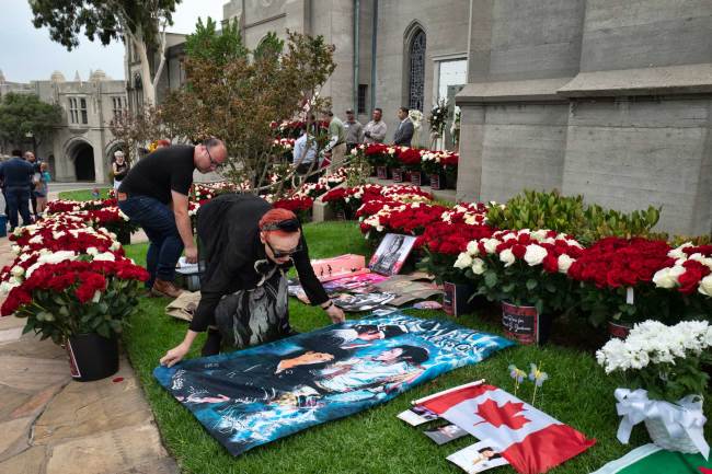 Carla Michael, of Florence Italy, lays out a Michael Jackson banner outside the late pop star's mausoleum on the 10th anniversary of his death at Forest Lawn Cemetery In Glendale, Calif. on Tuesday, June 25, 2019. [Photo: AP/Richard Vogel]