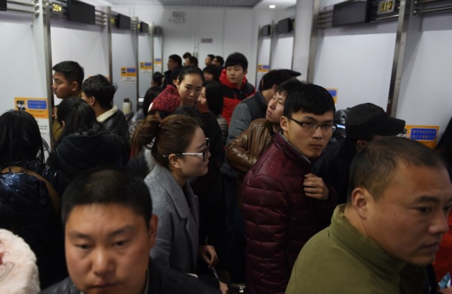 Job seekers walk past stalls at a job fair in Beijing on February 24, 2016. [Photo: AFP/ GREG BAKER] 
