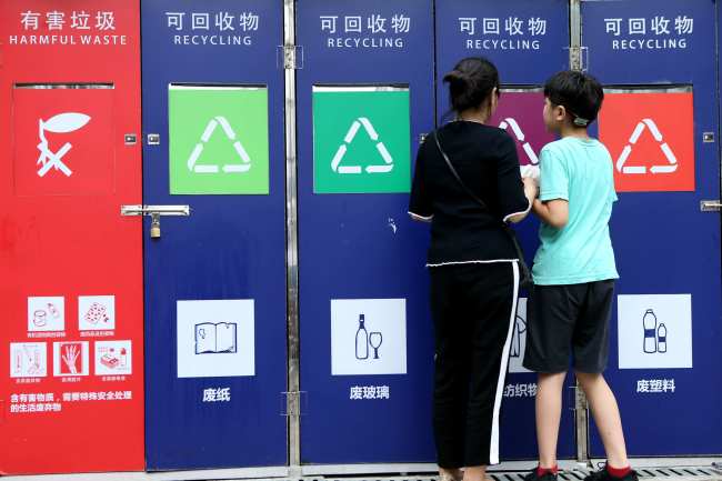 Residents throw rubbish into a smart bin deployed at a residential area in Shanghai on July 1, 2018. [Photo: IC]