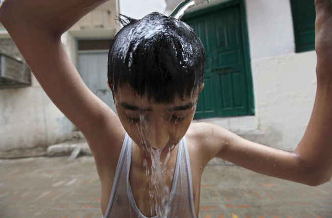 A boy was having a cold bathe to cool down on a hot day in Peshawar, Pakistan. 24.  June 2015.[Photo: from IC]