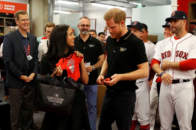 Britain's Prince Harry, Duke of Sussex and his wife Meghan, Duchess of Sussex react after being presented with gifts for their newborn son Archie, as they meet Boston Red Sox players ahead of their match against the New York Yankees at the London Stadium in Queen Elizabeth Olympic Park, east London on June 29, 2019, for the first of a two-game Baseball series in London. [Photo: AFP]