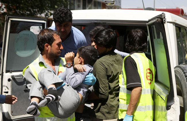 An Afghan health worker carries a wounded school student after a car bomb blast targeted a governmental institution in downtown Kabul, Afghanistan, July 1, 2019. [Photo: EPA via IC/Jawad Jalali]