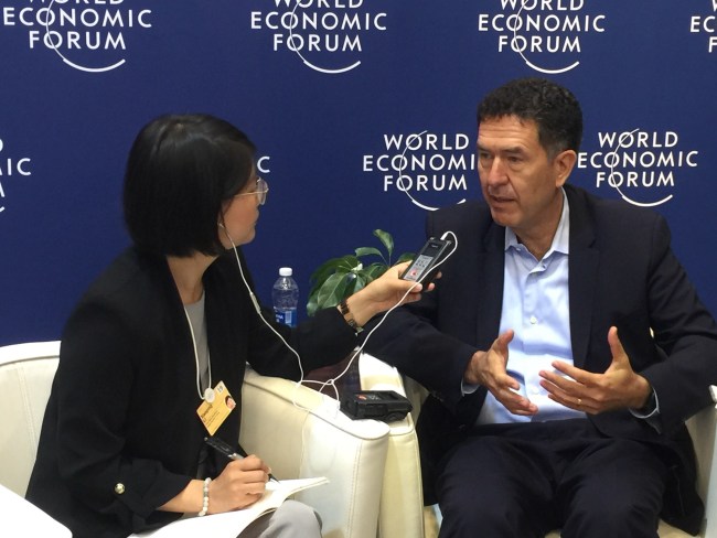 Murat Sonmez, right, speaks to a reporter on the sidelines of the Summer Davos forum in Dalian. [Photo: China Plus]