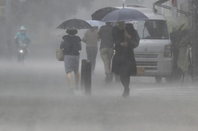 Pedestrians holding an umbrella struggle against a heavy rain in Miyazaki on July 2, 2019. A warning of sediment disaster due to torrential rain has been issued in southern Kyusyu Area. [Photo: IC]