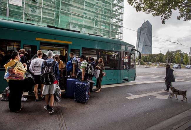 People leave the forbidden area near the European Central Bank, background, with a tram as 16 000 people are evacuated prior to the defusing of a WWII bomb in Frankfurt, Germany, Sunday, July 7, 2019. The bomb was discovered during construction works right next to the ECB. [Photo: IC]