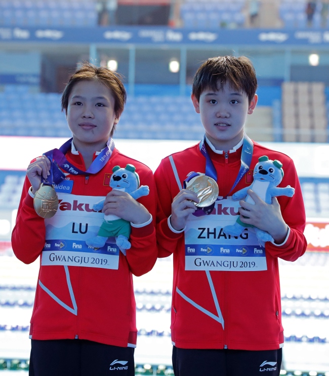 Gold medalists Lu Wei and Zhang Jiaqi of China smile after the medal ceremony for the Women's 10 meter Synchronized Platform Diving Final at the FINA Swimming World Championships 2019 in Gwangju, South Korea, 14 July 2019. [Photo: IC]