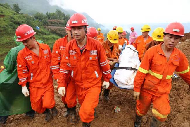 A rescuer carrying the body of a victim dug out of the debris caused by a landslide in Shuicheng County in Guizhou Province on Wednesday, July 24, 2019. [Photo: IC]