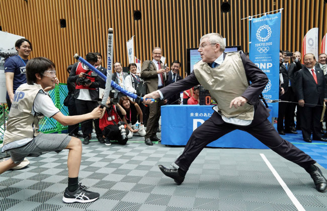 International Olympic Committee President Thomas Bach (R) fences at a promotional event in Tokyo on July 24, 2019, for the 2020 Olympics in the Japanese capital. The day marked the start of the one-year countdown to the opening of the Olympics. [Photo: Pool/Kyodo News via Getty Images via VCG]