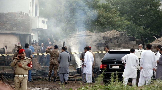 Pakistani security officials inspect the scene of a military plane crash on the outskirts of Rawalpindi, Pakistan, July 30, 2019. At least 17 people were killed and several others were wounded when a small military plane crashed in a residential area on the outskirts of Rawalpindi. [Photo: EPA via IC/Sohail Shahzad]