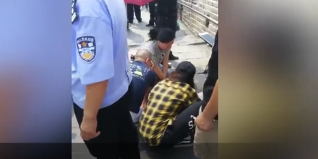 Screenshot of a video from yizhibo.com shows a group of Chinese people rescuing a 52-year-old female Japanese tourist who fainted at the Badaling section of the Great Wall. [Photo: China Plus]