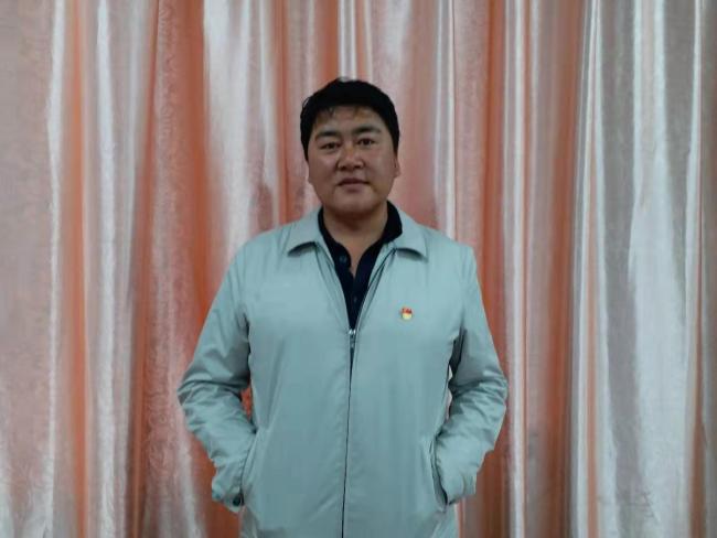 Zhu Zhui, the headmaster, has been serving Diqin Demonstration Elementary School for eight years. [Photo: from China Plus]    