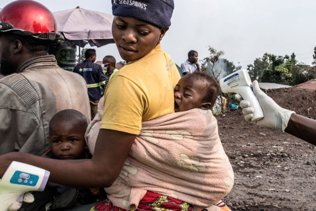 This photo issued on August 1, 2019 shows a health officer checking a baby's temperature at a health checkpoint in Goma, RD Congo on July 5, 2019. [File photo: EPA via IC/Patricia Martinez]