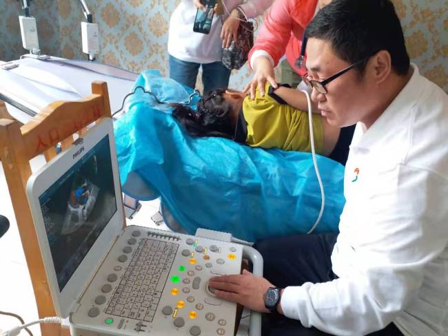Zhu Shuangli was doing ultrasound for a local boy to check if he had congenital heart disease. [Photo: from China Plus]  