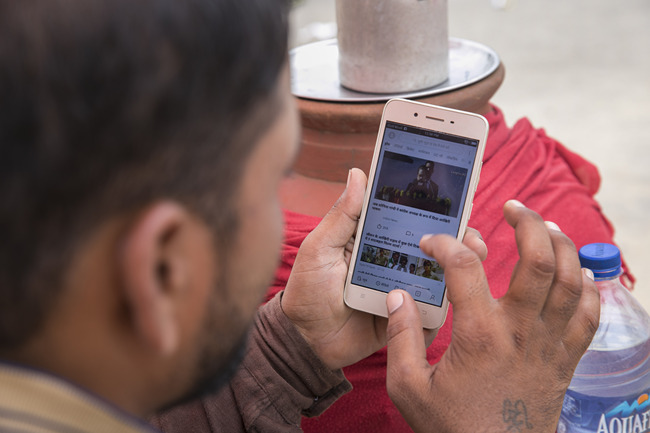 A man watches a video on his mobile phone. [File Photo: IC]