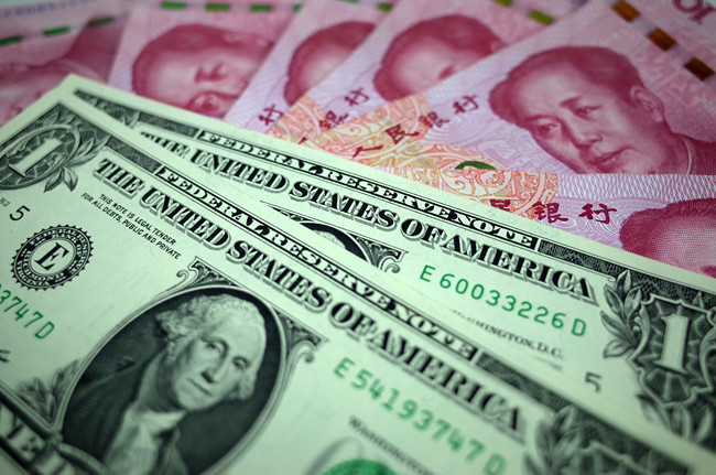 Chinese currency yuan and the U.S. dollars. [File Photo: IC]