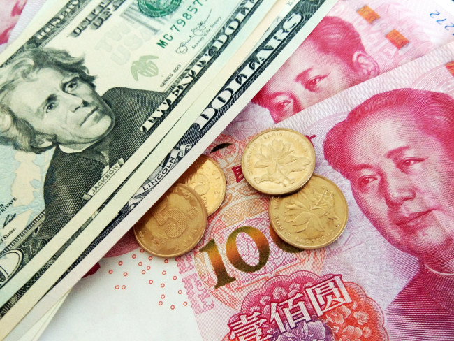 Chinese currency yuan and the U.S. dollars. [File Photo: IC]