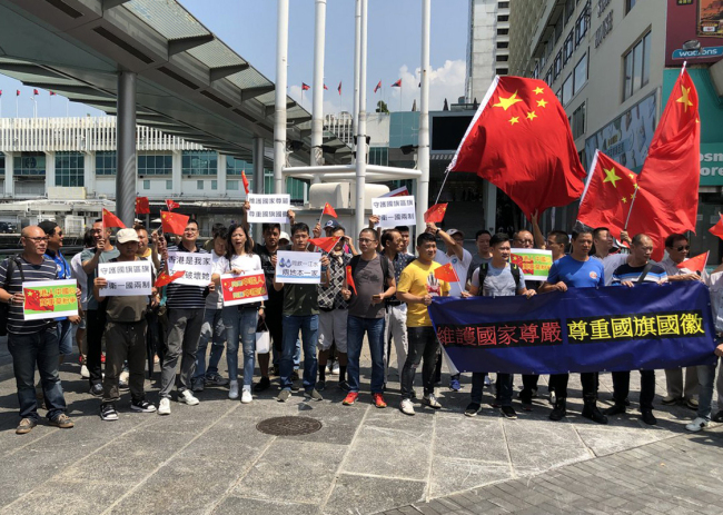 Hong Kong residents gather at a pier of the Victoria Harbor to express their reverence to the Chinese national emblem and flag on August 8, 2019. [Photo: China Plus]