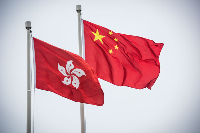 The Chinese national flag and the flag of the Hong Kong Special Administrative Region flutter in Hong Kong. [File Photo: IC]