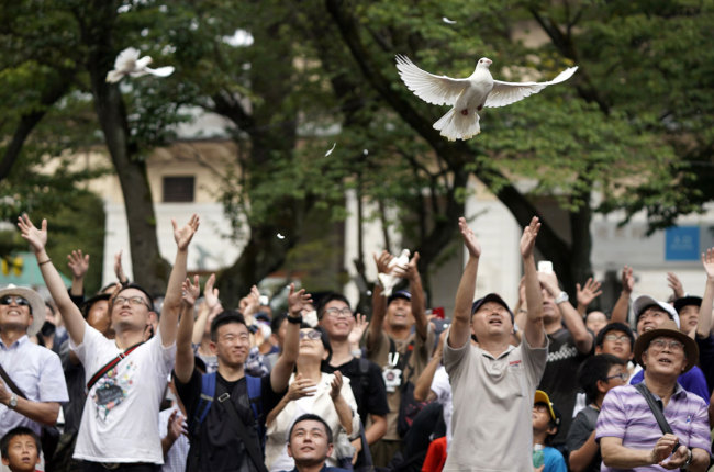 Visitors release white doves into the air, praying for war dead and peace at Yasukuni Shrine in Tokyo, Japan, 15 August 2019, the day of the 74th anniversary of the end of World War II. [EPA/FRANCK ROBICHON via IC]