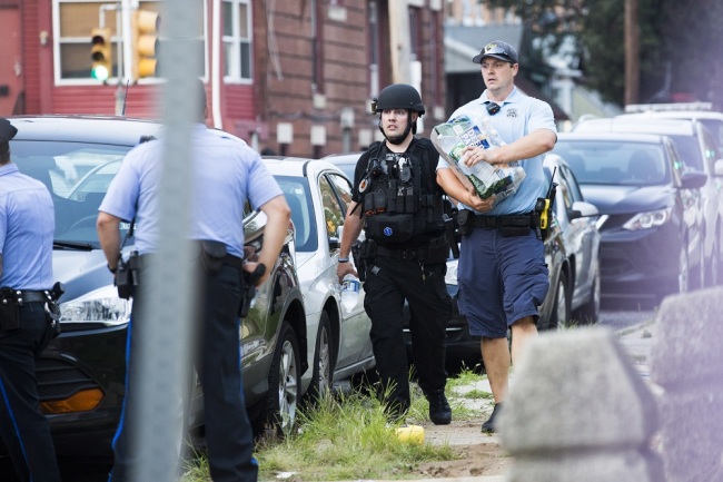 Police with automatic rifles walk away from the intersection of 15th Street and W Erie Avenue during an active police shooting in Philadelphia, Pennsylvania, USA, 14 August 2019. [Photo: EPA via IC/STRINGER]