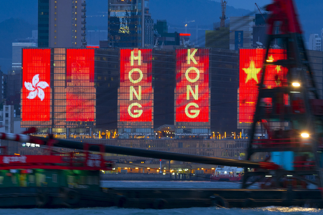 Neon lights at the shore buildings near the Victoria Harbor in the Hong Kong Special Administrative Region on June 26, 2017. The lights showed the flags of the People's Republic of China and the Hong Kong Special Administrative Region. [File Photo: IC]