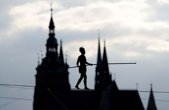 Tightrope walker Tatiana-Mosio Bongonga walks on a rope above the Prague Castle to open an international circus and theatre festival in Prague, Czech Republic, August 14, 2019. [Photo: Reuters via VCG/David W Cerny]