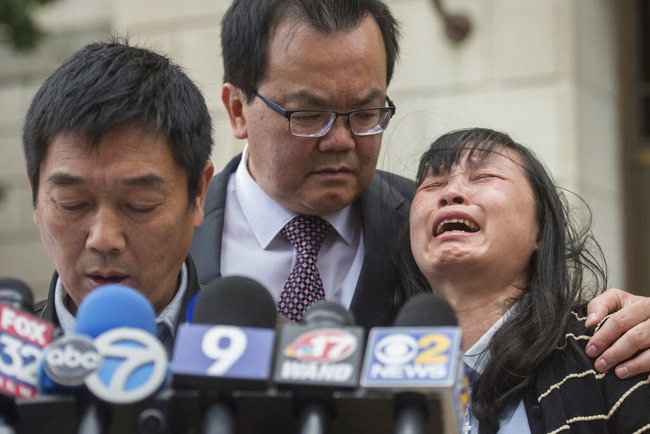 In this Monday, June 24, 2019 file photo, Lifeng Ye, the mother of slain University of Illinois scholar Yingying Zhang, cries out in grief as her husband Ronggao Zhang, left, addresses the media after a jury found Brendt Christensen guilty of Yingying Zhang's murder, at the U.S. Federal Courthouse in Peoria, Ill. [File Photo: Journal Star via AP/Matt Dayhoff]